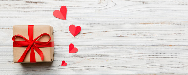 Wall Mural - Valentine day composition: red gift box with bow and heart. Christmas present. View from above. Space for text. Holday greeting card