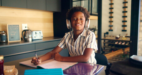 Poster - Child, portrait and headphones for education in home, homework and student listening to audio. African boy, writing notes and elearning podcast for studying, language project and mind development