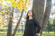 © Westend61 - Woman with eyes closed leaning on tree trunk in park