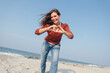 © Westend61 - Smiling woman making heart shape with hand at beach