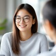 © Ankit - Smiling young woman with glasses in a meeting