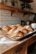 © Viktor - A tray of freshly baked croissants sitting on top of a wooden counter