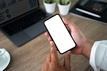 Wall Mural - Top view Mockup image hand using a smartphone man Holding Cell Phone With Blank Screen