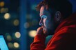 © Ankit - man in Red Hoodie Looks at Computer Screen at Night