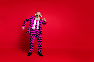 Full length photo of funky aged man amour cupid character role play dancing corporate party wear sun specs hearts pattern suit costume isolated vibrant color background