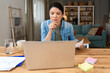 © Srdjan - Young confident businesswoman working at home office on laptop computer. Business owner professional occupation female, calculating and thinking, making innovations in e-commerce work with data.