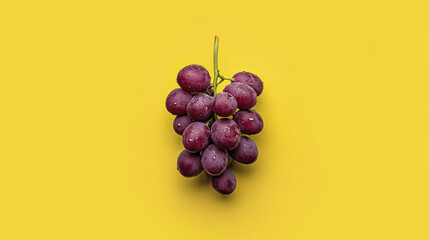 Fresh purple grapes on vibrant yellow background, showcasing their juicy texture and natural beauty