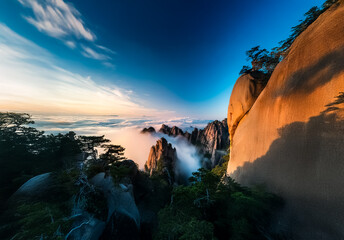 Poster - Breathtaking Chinese landscape view with majestic mountains piercing through misty clouds under a vibrant blue sky, showcasing nature's beauty.