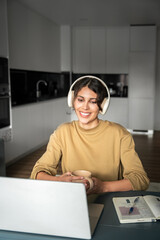 Canvas Print - Vertical portrait of young smiling latin freelance businesswoman using computer app for remote business studying watching webinar. IT student woman working on laptop pc at home, having online meeting