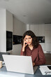 © Stock 4 You - Focused young businesswoman looking at laptop computer screen having headache, migraine. Serious freelance business woman watching reports feeling tired stressed, working remotely from home. Vertical