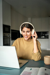 vertical portrait of young smiling latin freelance businesswoman using computer app for remote busin