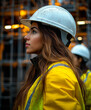 © Thanakorn - female engineer wearing hard hat and safety gear, looking thoughtfully at construction site. background features scaffolding and warm lighting, creating focused atmosphere