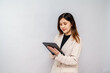 © kuenlin - Businesswoman Using Digital Tablet with Stylus for Work,Professional Woman Writing on a Tablet in a Corporate Setting