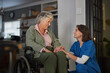 © Rido - Nurse talking to happy senior woman on wheelchair