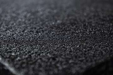 Close-up of black stone surface, featuring fine, smooth grains and a polished finish with natural variations in shade.