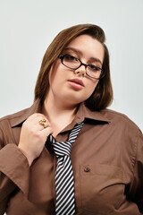 Wall Mural - Young plus size woman showcasing confidence in a stylish outfit with a tie