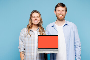 Wall Mural - Young couple two friends family IT man woman wearing shirt casual clothes together hold use work on laptop pc computer with blank screen workspace area isolated on pastel plain blue background studio.