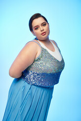 Wall Mural - Radiant plus size woman shines in sparkling attire against a vibrant blue backdrop