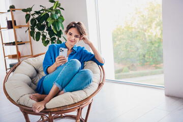 Poster - Photo of cute pretty girl sitting on comfortable armchair reading instagram telegram post light room indoors