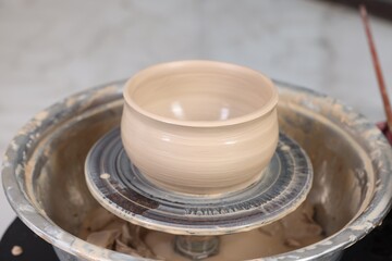 Wall Mural - Hobby and craft. Beautiful bowl on potter's wheel in workshop, closeup