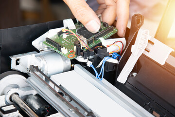 Poster - top view of technician inspecting and repairing printer and motherboard.