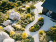© mikhailberkut - Modern desert landscape design with drought-resistant plants and rock garden pathway