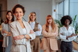 © bernardbodo - Smiling businesswoman posing in front of her colleagues