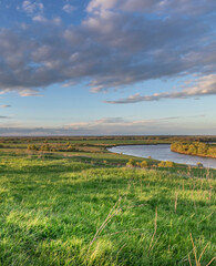 Wall Mural - field of grass with a river running through it