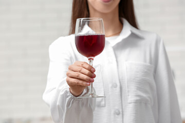 Wall Mural - Young woman with glass of red wine on white background, closeup