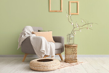 Wall Mural - Vase with tree branches and Easter eggs on coffee table in festive living room