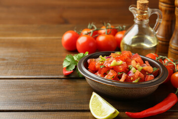 Wall Mural - Delicious spicy salsa with ingredients on wooden table. Space for text