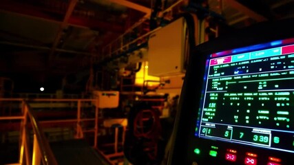 Aufkleber - Green data is displayed on a digital control panel in an engine room of a ship at night, providing information about the vessel's systems and performance