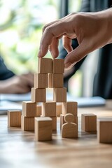 Poster - Businessman building a structure with wooden blocks