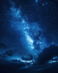 Wall Mural - ethereal night sky displaying the milky way galaxy above dark clouds in a celestial blue tone