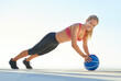 © peopleimages.com - Happy woman, portrait and workout with push up on medicine ball for exercise, fitness or muscle gain on floor. Active, female person or training with blue sky, lifting body weight or core for balance