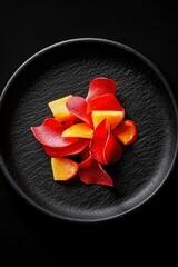 Wall Mural - Artistic food plating with petals and fruit on a black plate for healthy diet