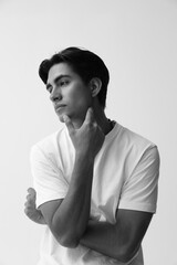 Black and white casual headshot of handsome man posing over white background. Vertical.