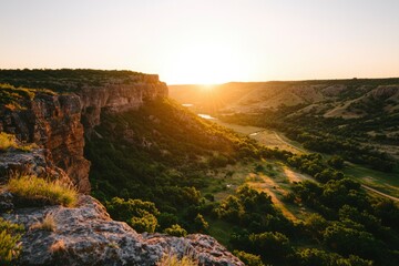 Wall Mural - Cliffside view of a canyon at sunset, sunbeams in the background, landscape shot