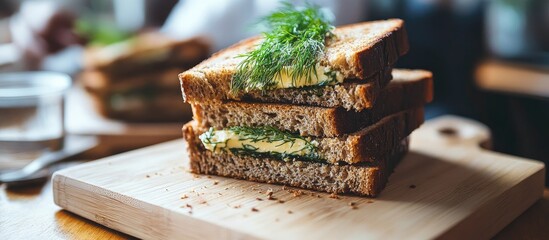 Poster - Cereal bread sandwiches layered with butter and fresh dill stacked on a wooden cutting board, soft natural light highlighting the textures.