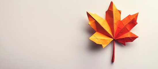 Poster - Vibrant autumn hues of orange and yellow origami maple leaf positioned on the right over a soft white background with gentle shadows.