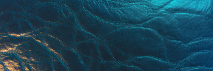 Poster - Textured navy blue leather with scratches illuminated by cool lighting