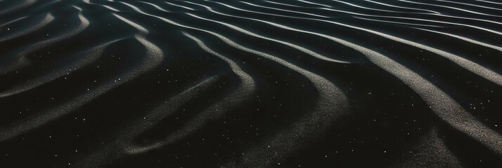 Poster - Black sand dune with rippled texture and soft lighting creating unique patterns