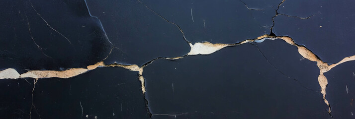 Fototapete - Cracked black wall texture with light grey details in urban setting