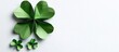 © meristock - Green paper origami shamrock clover leaves in various sizes positioned left on a white background St Patrick's Day greeting card space for text