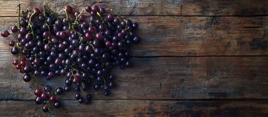 Poster - Fresh black currant berries in clusters on a rustic wooden surface with rich purple hues contrasting against the warm brown texture of the wood.