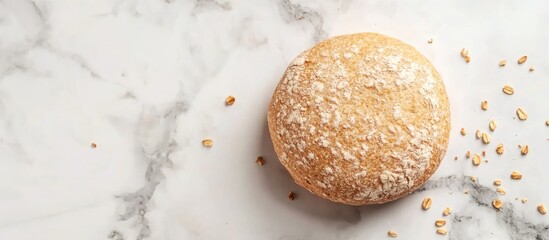 Poster - Rustic golden bread roll with a crusty surface, scattered oats, placed on a textured white marble background with soft natural lighting.