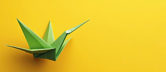 Poster - Green origami crane on vibrant yellow background positioned left, showcasing intricate folds and shadows for a cheerful, artistic composition.