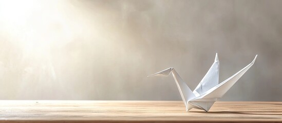 Leinwandbilder - Origami crane placed elegantly on a wooden table with soft light beams illuminating a neutral background creating a serene atmosphere