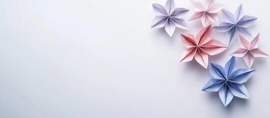 Leinwandbilder - Colorful origami flowers in shades of pink and blue arranged artistically on a soft white background creating a serene floral composition.