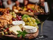 © Anastasiya - A rustic cheese platter with creamy brie, fresh grapes, crusty bread, and a glass of red wine, creating a warm and elegant dining atmosphere